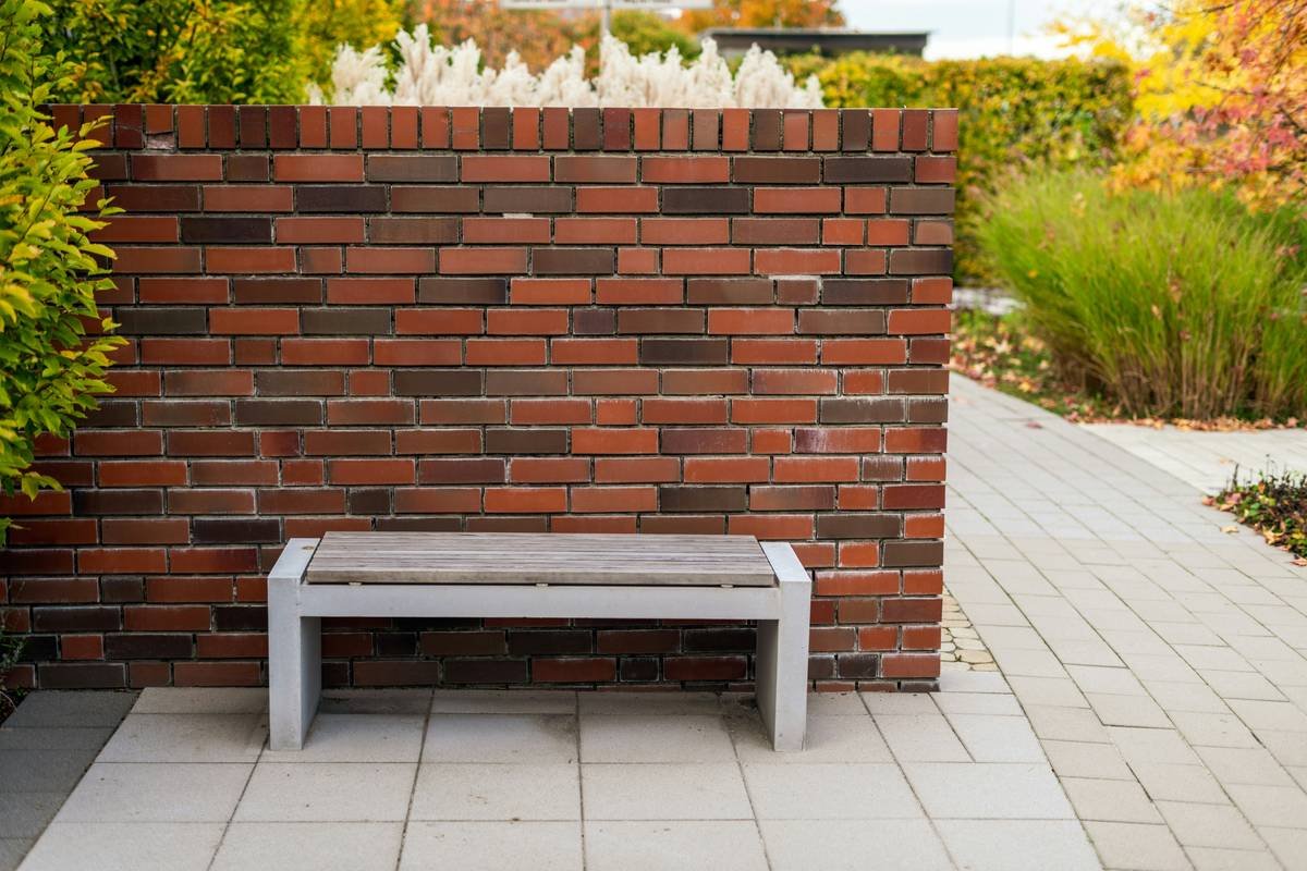 Weather-resistant garden benches outdoor made from HDPE plastic on a suburban patio with blooming hydrangeas